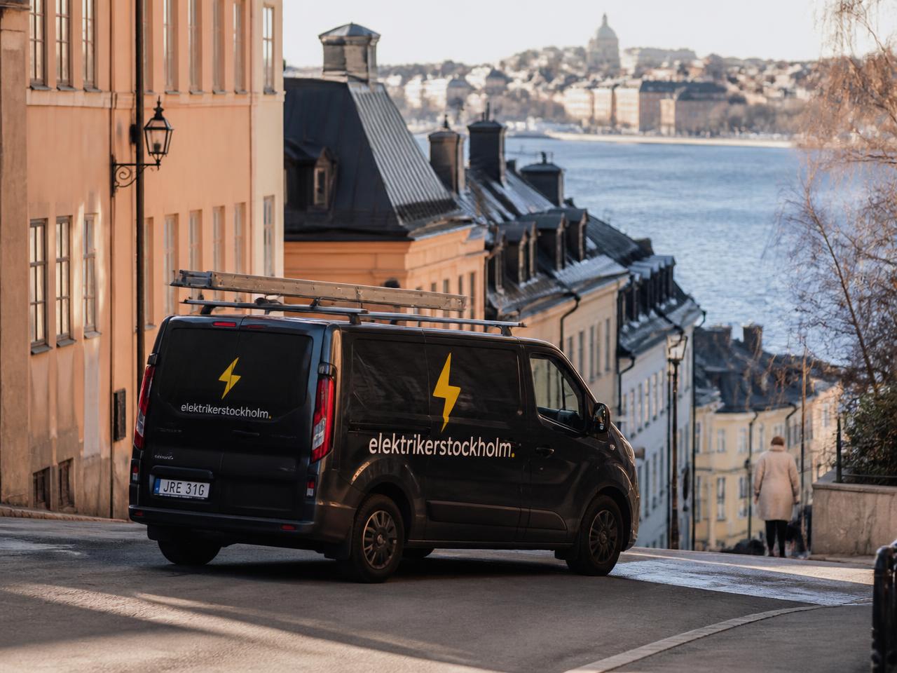 Utsikt över Stockholms tak och vatten i varmt kvällsljus